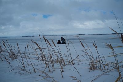 Man fishing in sea against sky