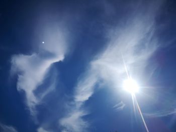 Low angle view of sunlight streaming through clouds