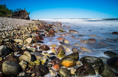 Pebbles on beach against sky