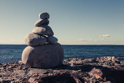 Rocks on beach against clear sky