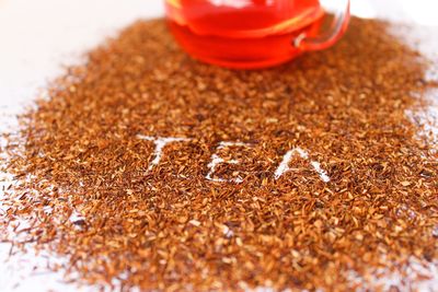 High angle view of text on scattered tea leaves against white background