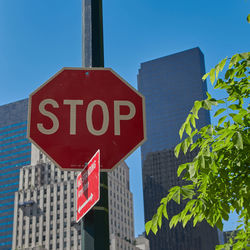 Low angle view of road sign against buildings in city