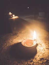 Close-up of lit candle in the dark