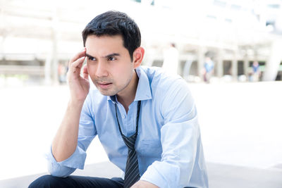 Frustrated businessman sitting outdoors