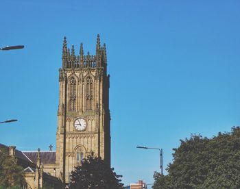 Low angle view of bell tower against blue sky