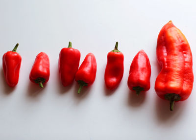 Close-up of red chili peppers against white background