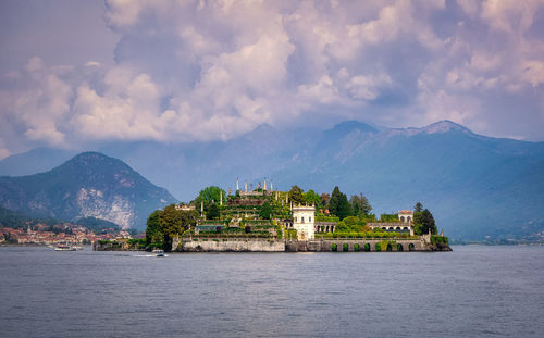 Buildings by sea against sky