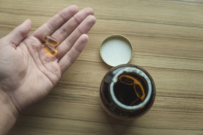 Yellow transparent omega 3 capsules in hand. taking medications. nutritional supplements
