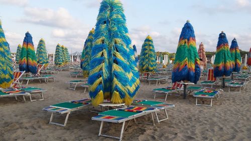 Closed canopies on beach against the sky