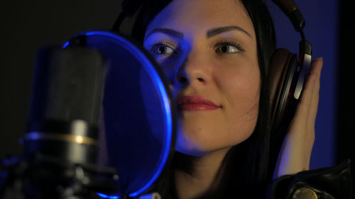 Smiling singer wearing headphones at recording studio