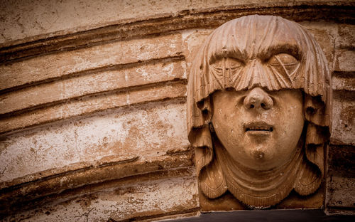 Close-up of buddha statue against wall