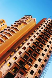 Low angle view of buildings against clear blue sky