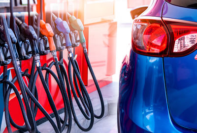 Blue luxury suv car fueling at gas station. refuel fill up with petrol gasoline. petrol pump filling