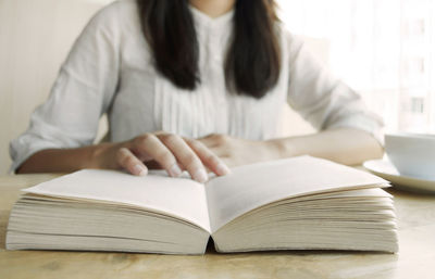 Midsection of woman reading book