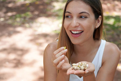 Portrait of smiling young woman sitting on field