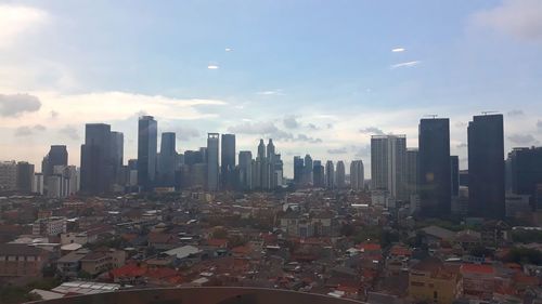 Aerial view of buildings in city against sky