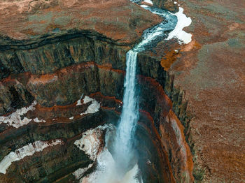 Aerial view on hengifoss waterfall with red stripes sediments in iceland.