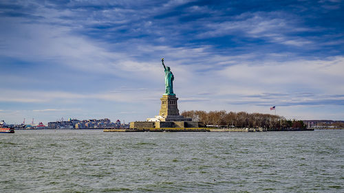 Statue of liberty against sky in city