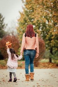 Rear view of women standing against trees