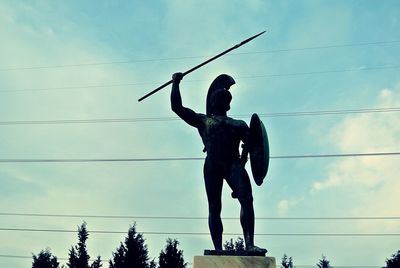 Low angle view of leonidas statue against sky