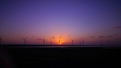 Silhouette of wind turbines at sunset