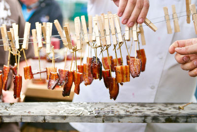 Close-up of hands drying meat outdoors