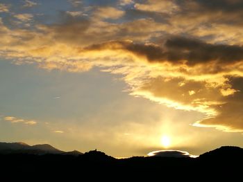 Low angle view of silhouette mountain against dramatic sky