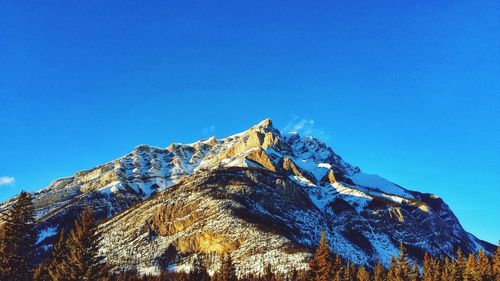 Low angle view of mountain against clear blue sky