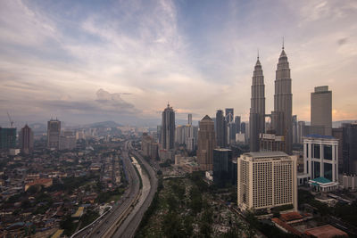 View of cityscape against cloudy sky