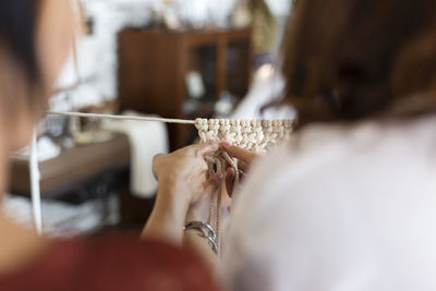 Close-up of women making macrame