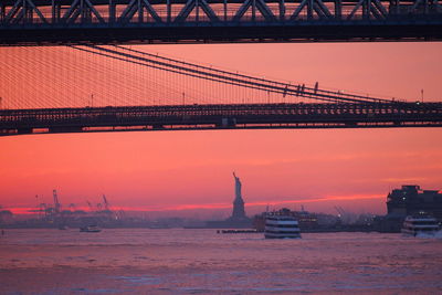 Bridge over river against sky during sunset