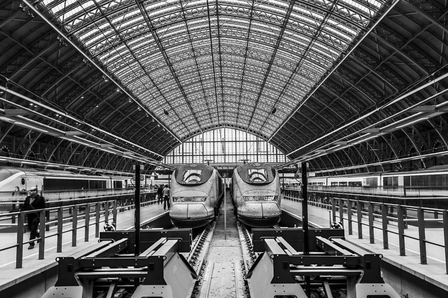 indoors, ceiling, architecture, built structure, lifestyles, railing, steps, high angle view, steps and staircases, men, incidental people, railroad station, interior, staircase, pattern, leisure activity, standing, full length