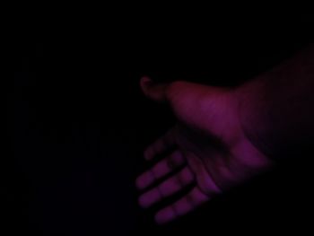 Close-up of hand against black background