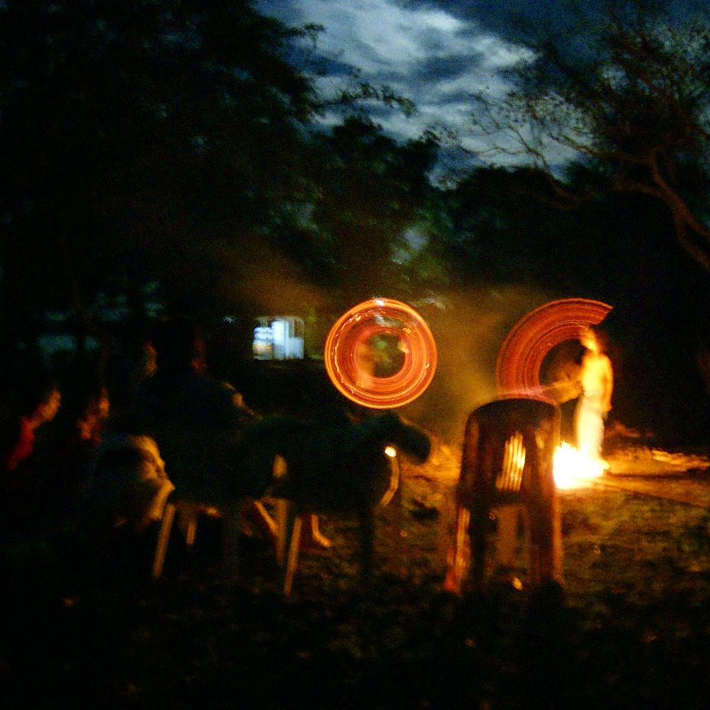 illuminated, night, burning, flame, glowing, leisure activity, fire - natural phenomenon, lifestyles, men, silhouette, motion, lighting equipment, field, light - natural phenomenon, sky, celebration, unrecognizable person, long exposure