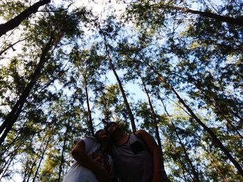 Low angle view of woman on tree trunk