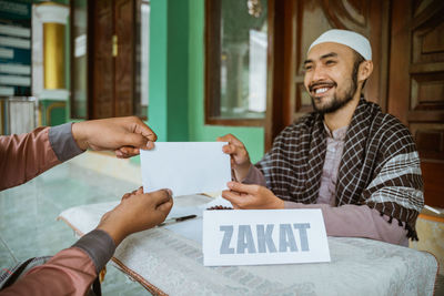 Young man taking charitable donation at mosque