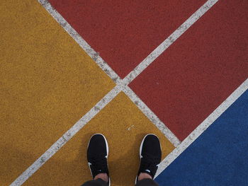 Low section of man standing on zebra crossing
