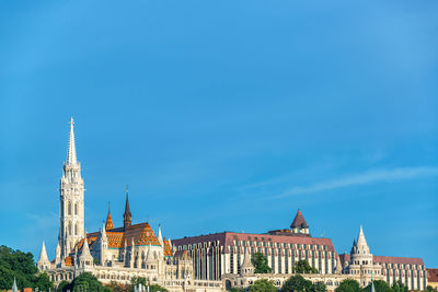 Buildings in city against blue sky