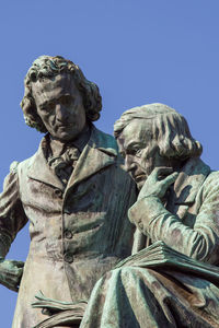 Low angle view of statue against clear blue sky