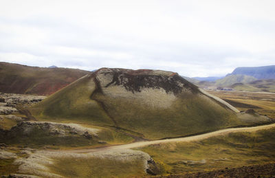 Scenic view of mountain against cloudy sky