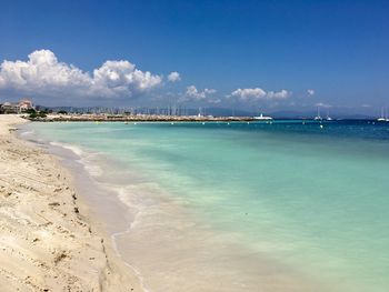 Scenic view of beach against blue sky