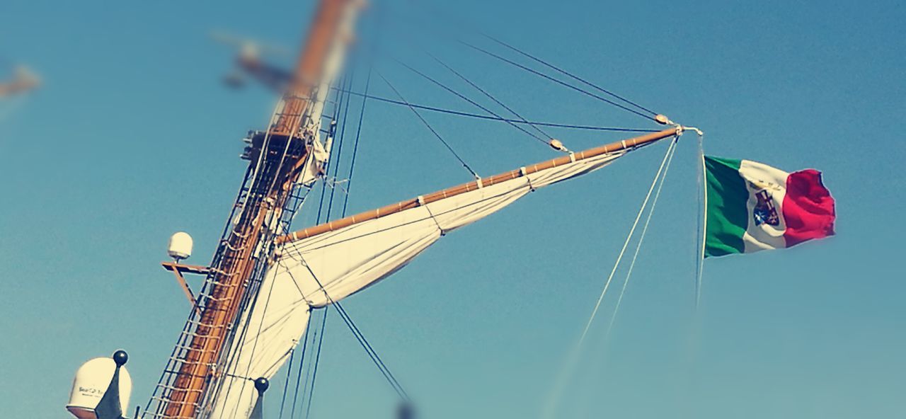 low angle view, blue, clear sky, day, sailboat, sky, outdoors, no people, large, national flag, development