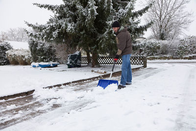 Man standing on snow covered trees