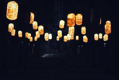 Illuminated lanterns hanging against black background