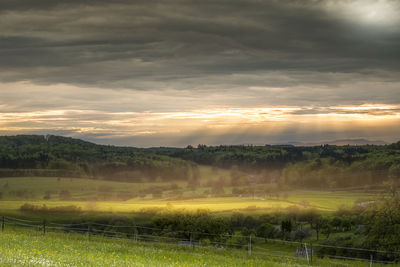 Scenic view of field against sky at sunset