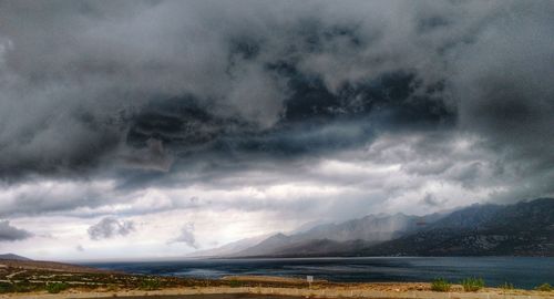 Scenic view of lake against storm clouds