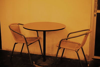 Empty chairs and table against wall at home