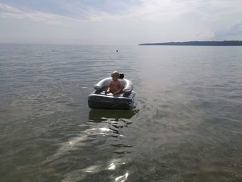 Rear view of man on sea against sky