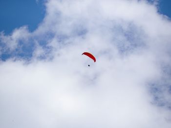 Low angle view of person paragliding against sky