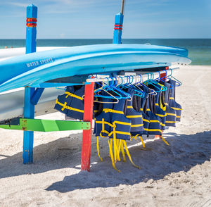 Deck chairs on beach against blue sky